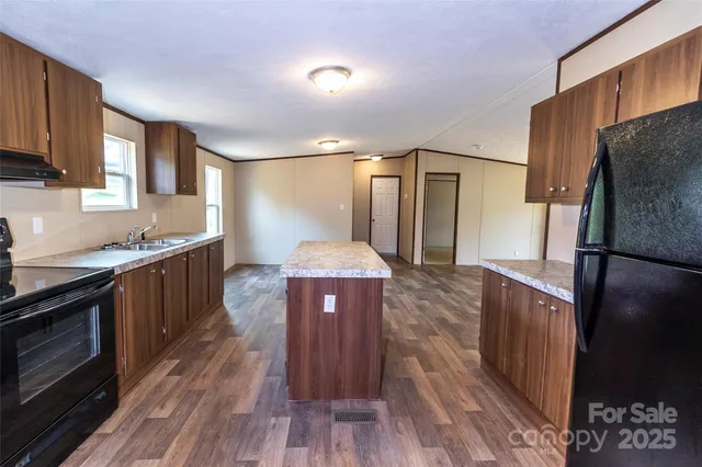 a kitchen with a sink a stove a refrigerator and wooden cabinets