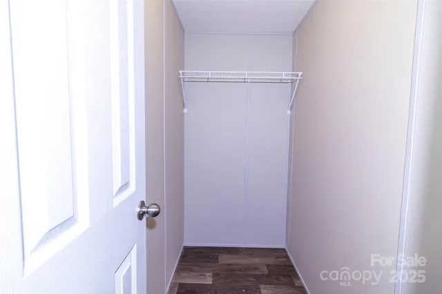 a view of a room with wooden floor and a window