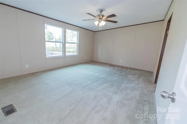 an empty room with closet and a chandelier fan