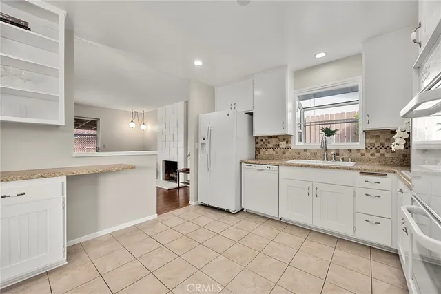 a kitchen with a refrigerator and white cabinets