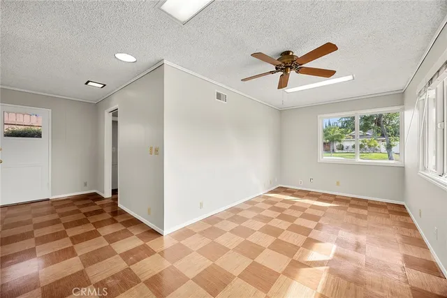 a view of a livingroom with a chandelier fan and windows