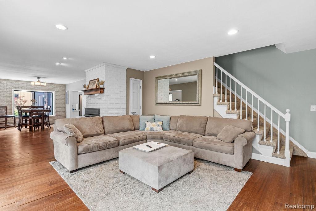 11111 Hibner Road Hartland, MI 48353 - Photo 25 of 59 Living room featuring brick wall, wood-type flooring, recessed lighting, and a fireplace