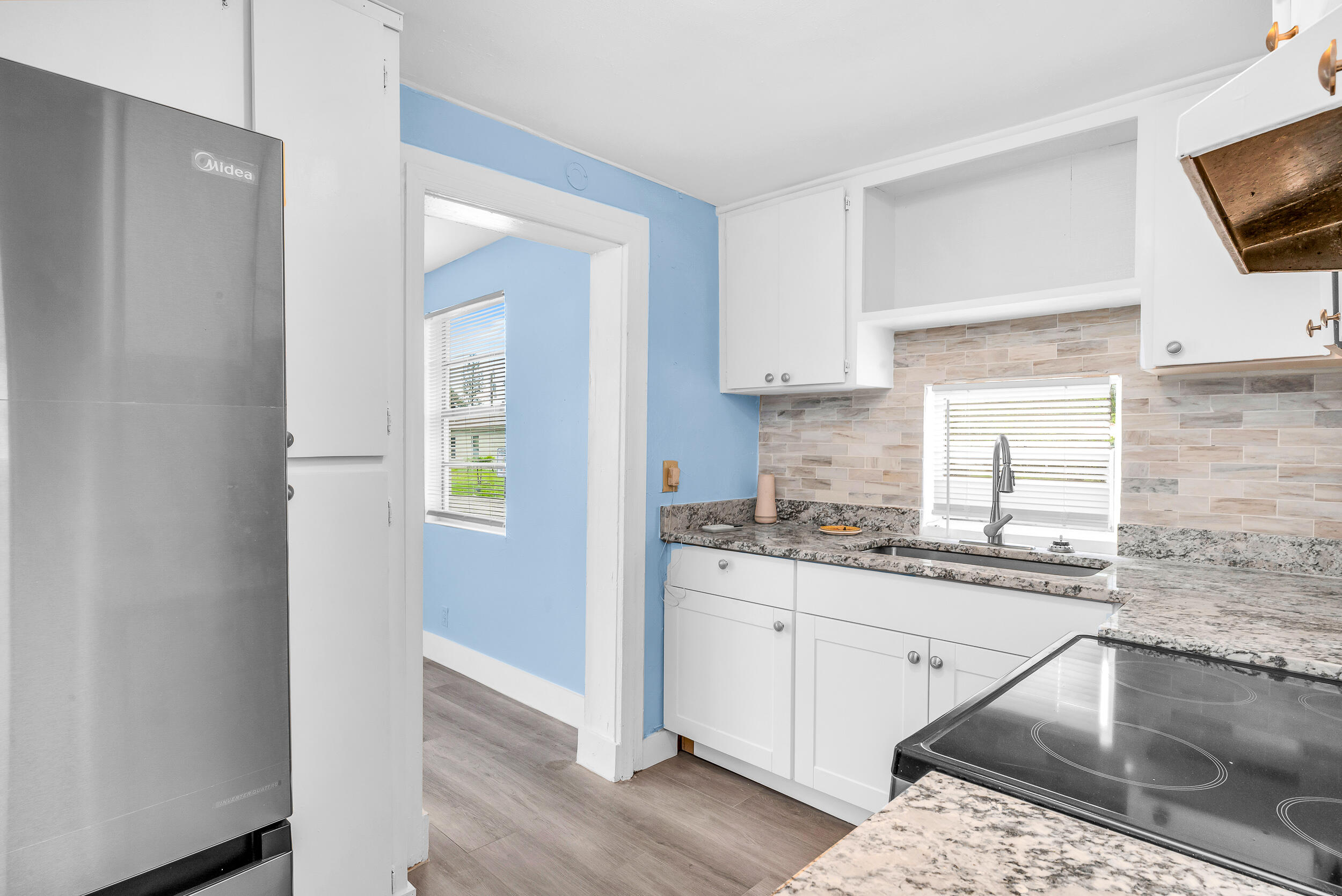 1497 Silver Beach Road Riviera Beach, FL 33404 - Photo 2 of 14 a kitchen with granite countertop a sink a stove and cabinets
