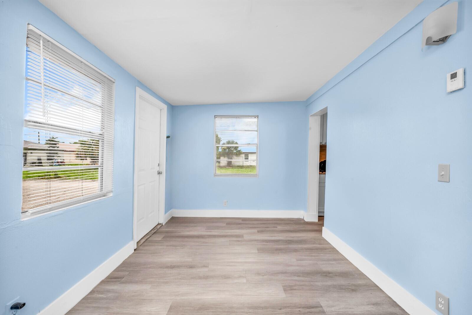 1497 Silver Beach Road Riviera Beach, FL 33404 - Photo 7 of 14 a view of an empty room with wooden floor and a window