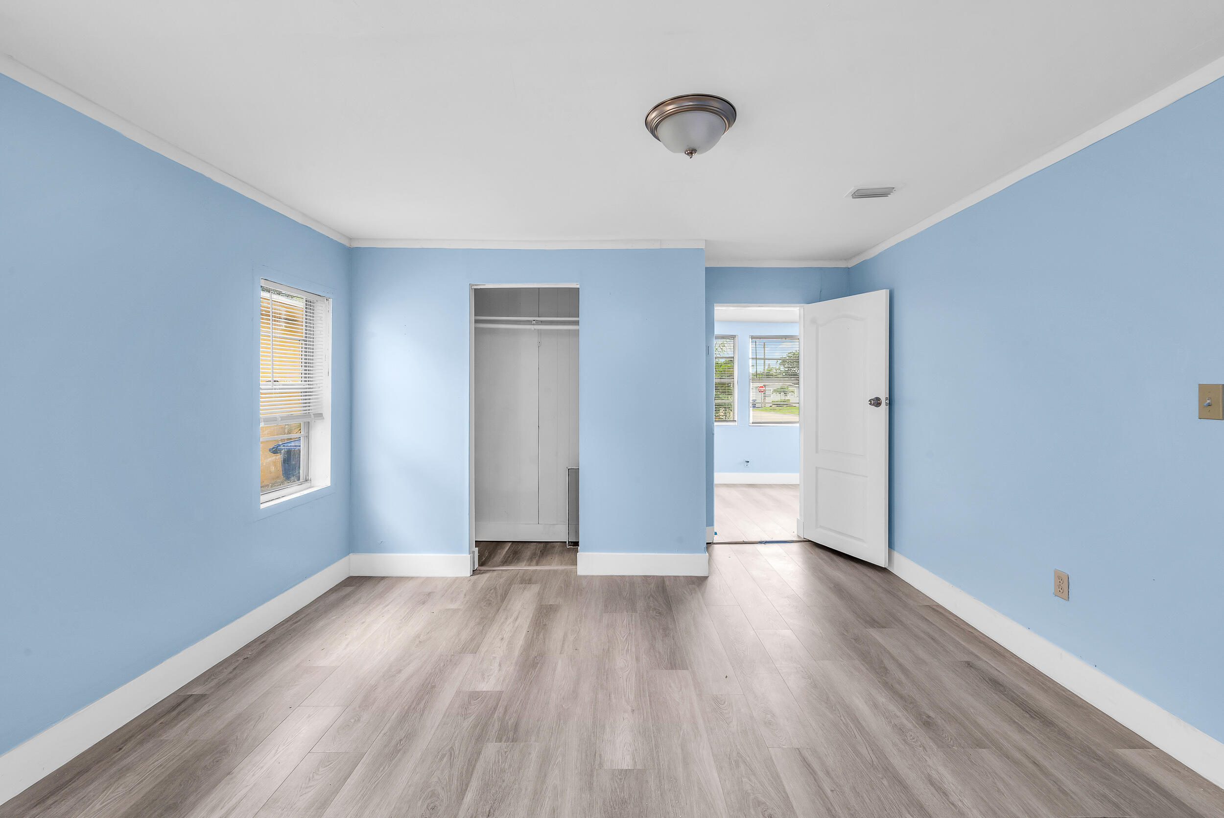 1497 Silver Beach Road Riviera Beach, FL 33404 - Photo 9 of 14 an empty room with wooden floor and windows