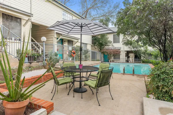 a view of a patio with table and chairs under an umbrella
