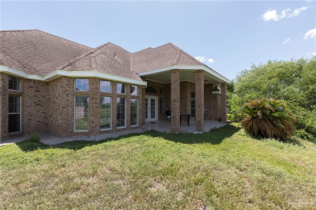 1213 Rhett Drive Pharr, TX 78577 - Photo 18 of 19 Rear exterior featuring a covered patio with peaceful water and golf course views.