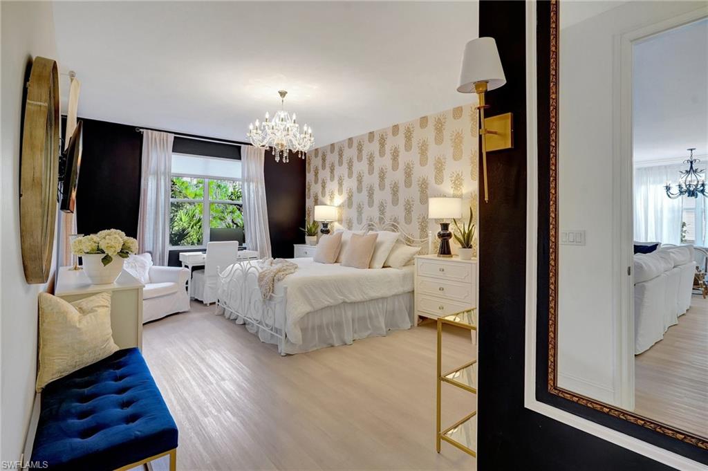 889 Carrick Bend Circle, Unit 1701 Naples, FL 34110 - Photo 23 of 32 a spacious bedroom with a bed and a couch