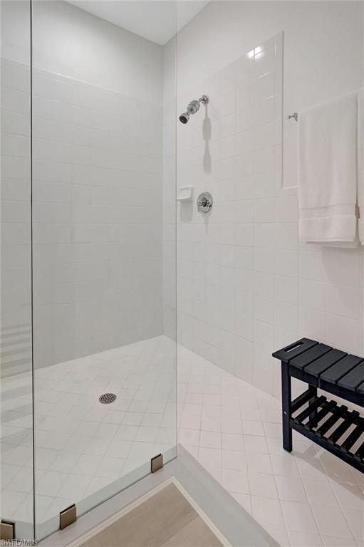 889 Carrick Bend Circle, Unit 1701 Naples, FL 34110 - Photo 27 of 32 a bathroom with a bathtub and a shower
