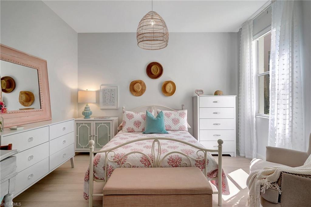 889 Carrick Bend Circle, Unit 1701 Naples, FL 34110 - Photo 28 of 32 a bedroom with a bed and cabinets