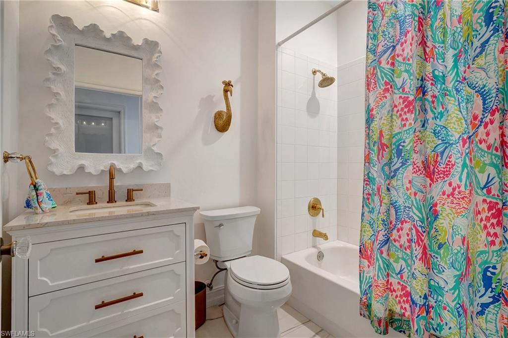 889 Carrick Bend Circle, Unit 1701 Naples, FL 34110 - Photo 32 of 32 a bathroom with a sink mirror vanity and toilet