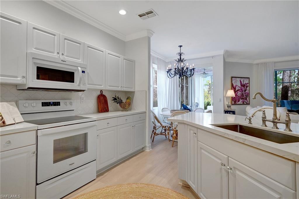 889 Carrick Bend Circle, Unit 1701 Naples, FL 34110 - Photo 7 of 32 a kitchen with a sink stove and microwave