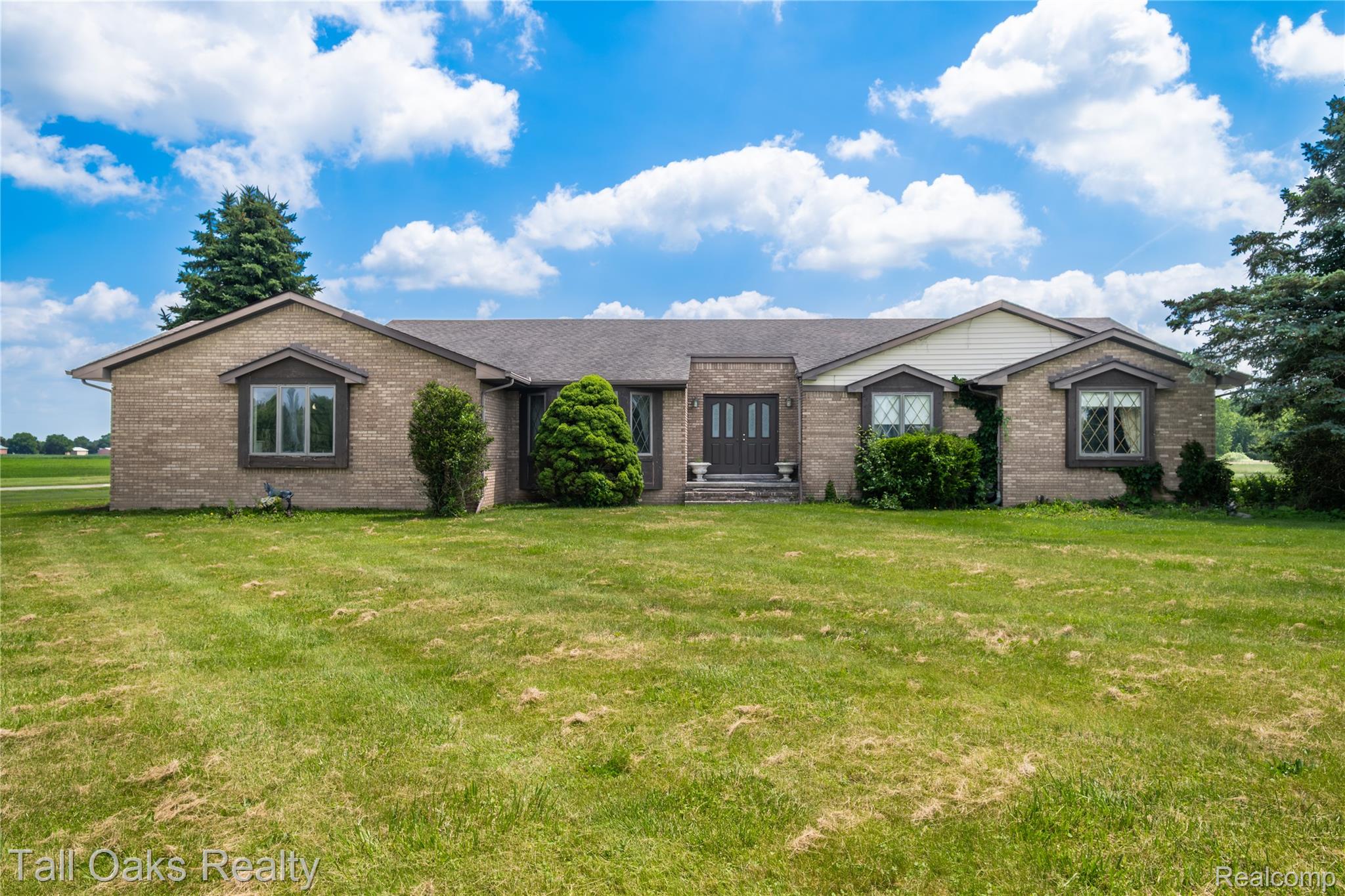 79330 Capac Road Armada, MI 48005 - Photo 20 of 42 Brick exterior with a central double door entry featuring decorative glass inserts