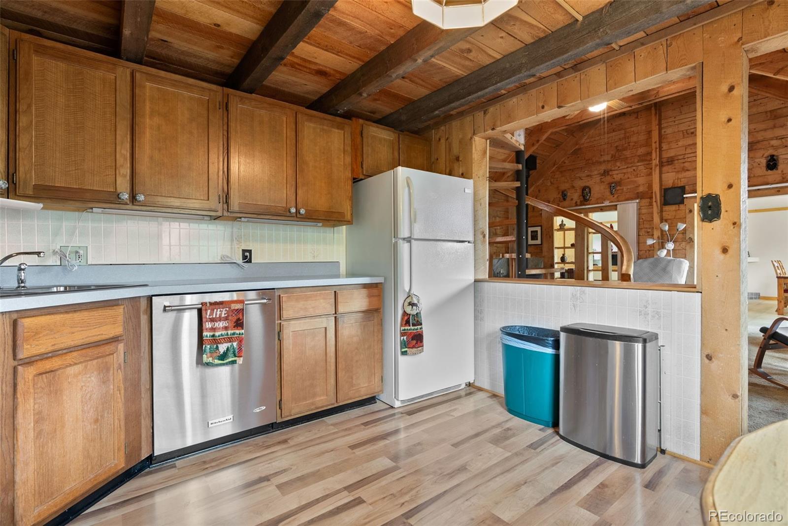 62 Quartz Circle Bailey, CO 80421 - Photo 15 of 38 a kitchen with stainless steel appliances granite countertop a refrigerator a sink dishwasher and white cabinets with wooden floor