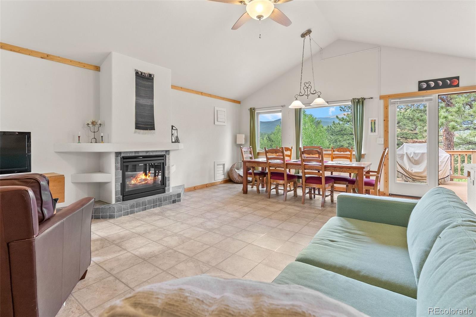 62 Quartz Circle Bailey, CO 80421 - Photo 27 of 38 a living room with furniture a fireplace and a floor to ceiling window