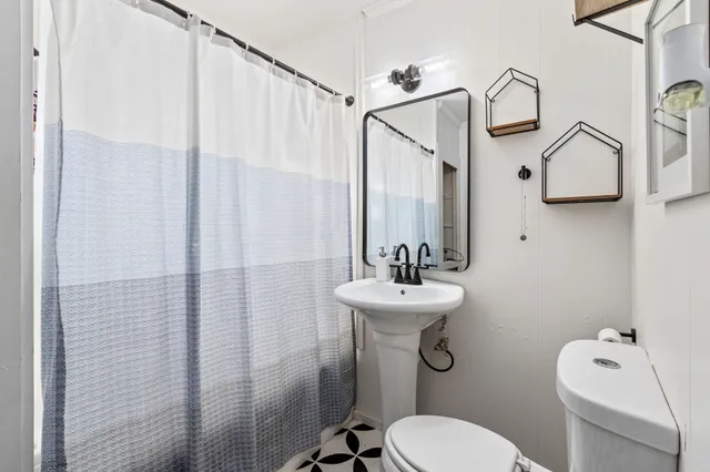 a bathroom with a toilet a sink and mirror