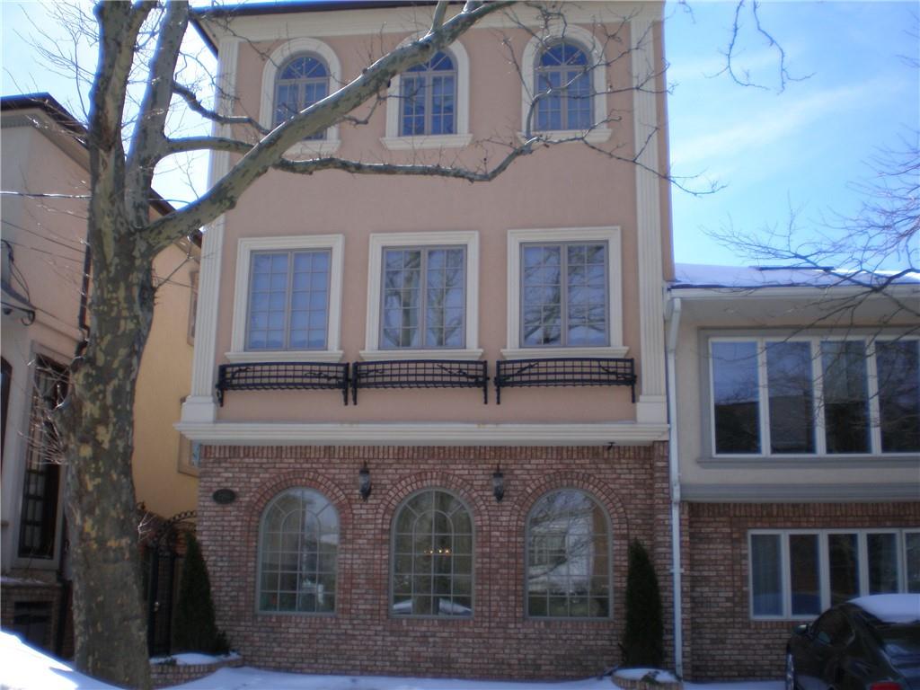 front view of a brick house with large windows