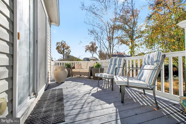 a balcony with wooden floor table and chairs