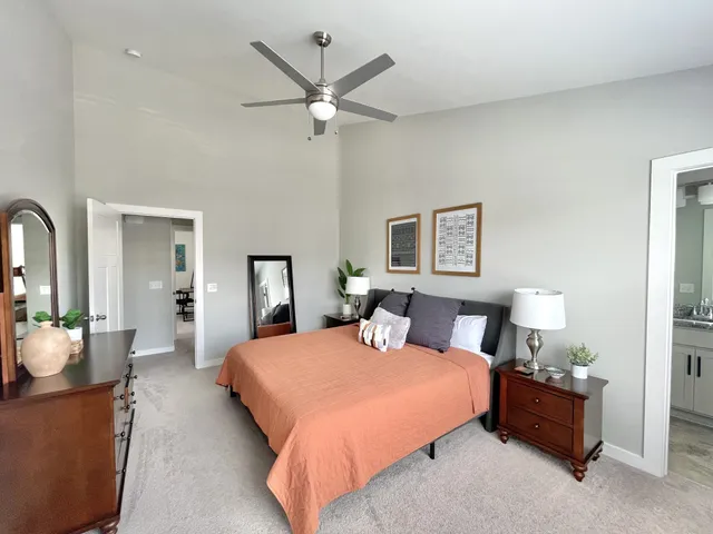 a bedroom with a large bed and a chandelier