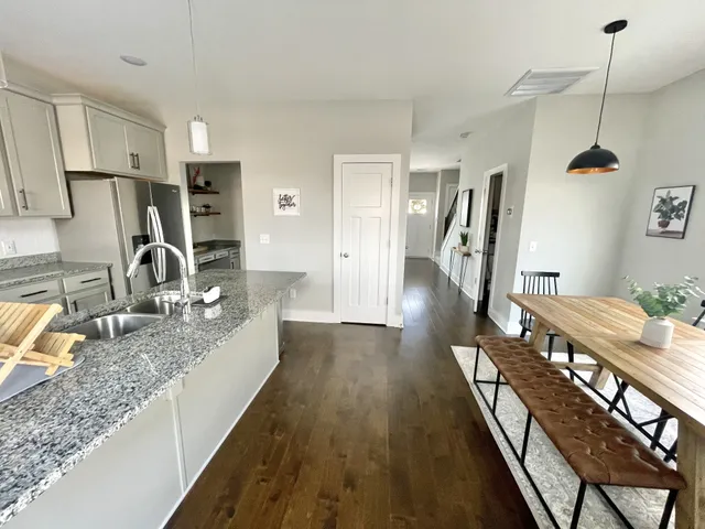 a view of a kitchen with sink and refrigerator