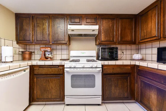 a kitchen with wooden cabinets and a stove top oven