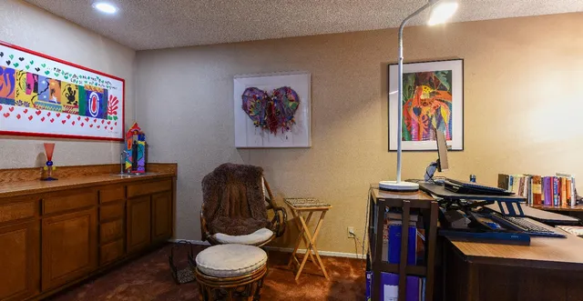a view of a workspace with furniture and wooden floor