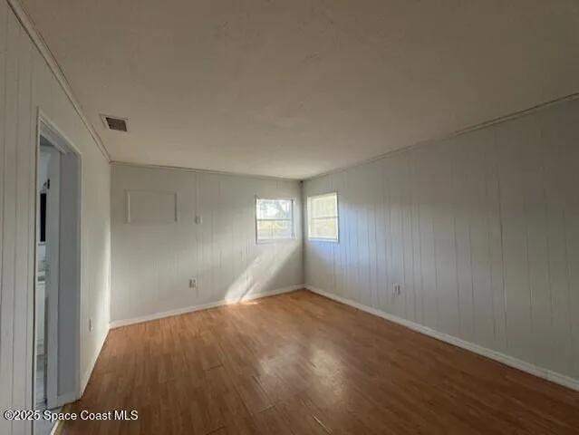 a view of an empty room with a window and fire place