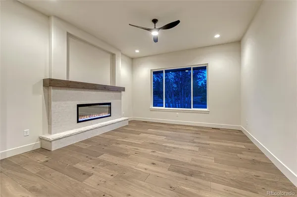 a view of an empty room with a fireplace and a window