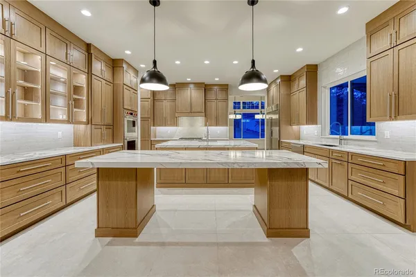 a kitchen with kitchen island a sink and a chandelier