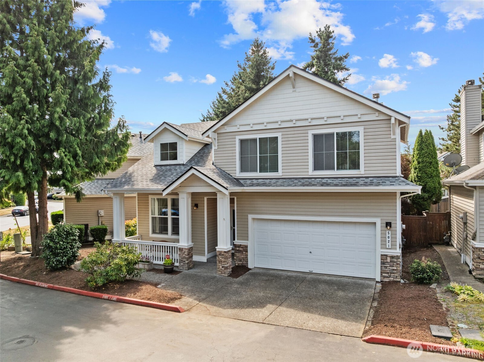 5021 South 232nd Street, Unit 75 Kent, WA 98032 - Photo 2 of 40 a front view of a house with a yard and garage