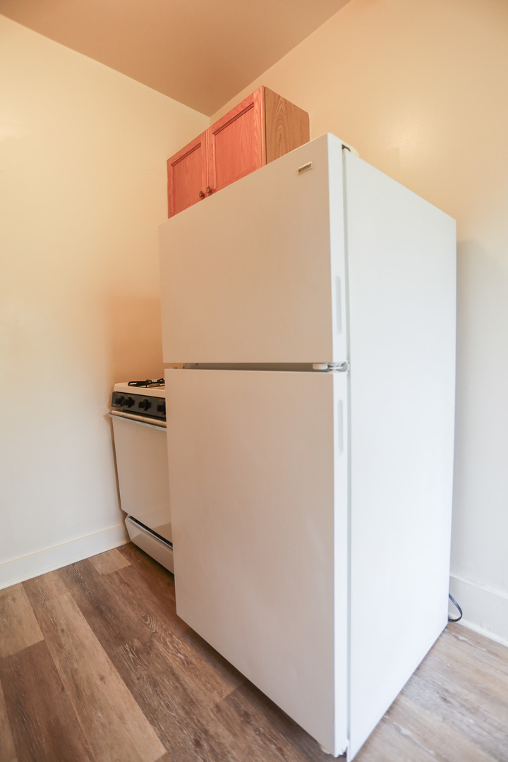 1100 West Roscoe Street, Unit 13 Chicago, IL 60657 - Photo 2 of 9 a view of a refrigerator in kitchen and an empty room