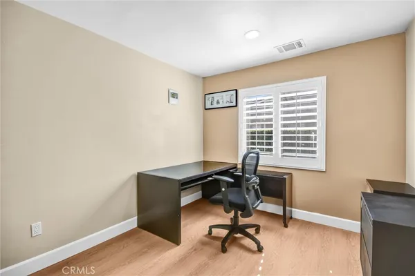 a view of a workspace with furniture and a window