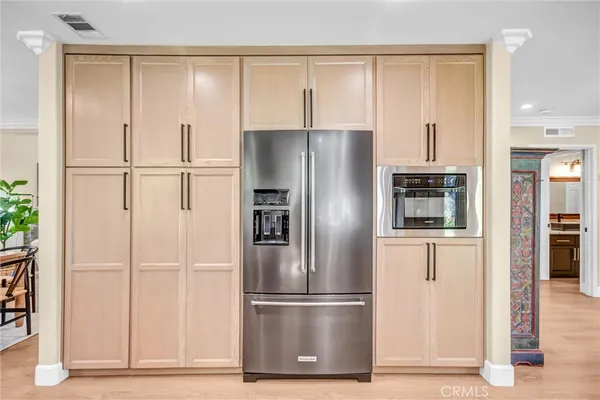 a metallic refrigerator freezer and a wooden floor