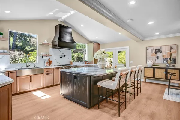 a kitchen with stainless steel appliances granite countertop a stove a sink a refrigerator and a dining table