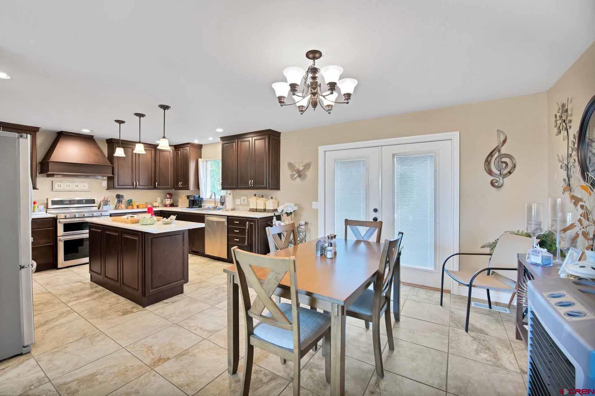 10487 2100th Road Austin, CO 81410 - Photo 12 of 35 a kitchen with stainless steel appliances a stove a sink a dining table and chairs