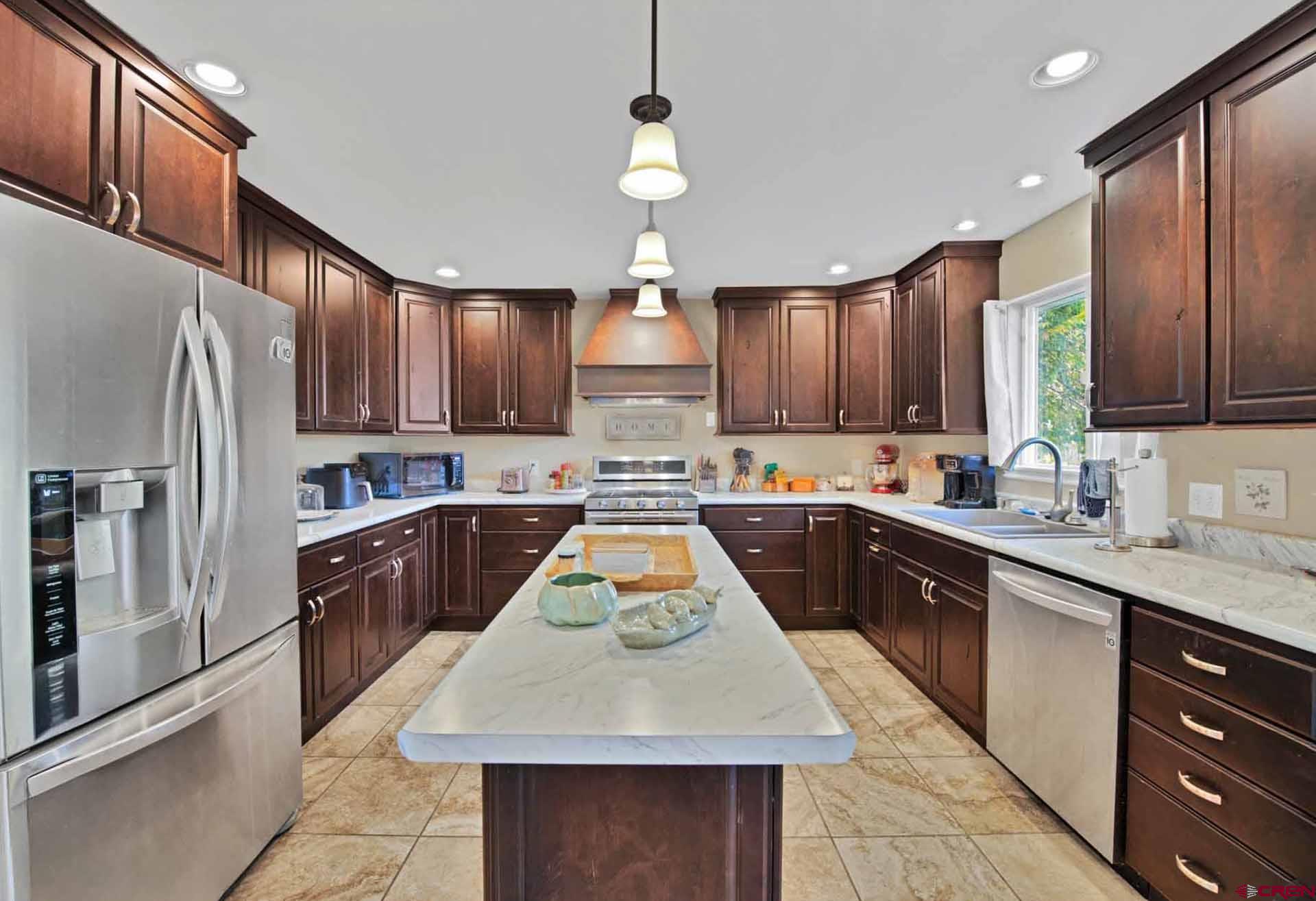 10487 2100th Road Austin, CO 81410 - Photo 13 of 35 a kitchen with kitchen island granite countertop wooden cabinets a refrigerator stove a sink and dishwasher with wooden floor