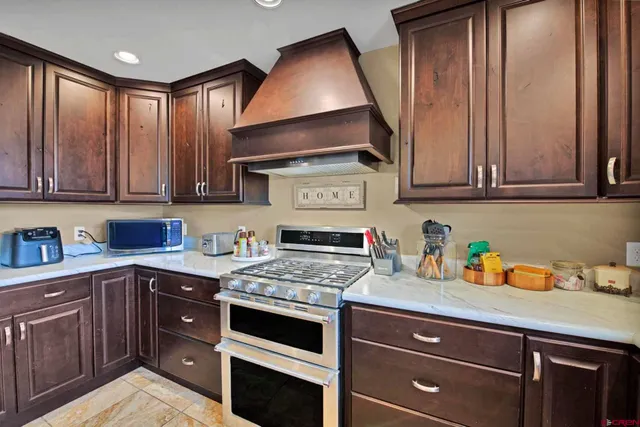 a kitchen with stainless steel appliances granite countertop a stove a sink and a microwave