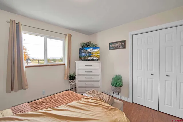 a bedroom with a bed a dresser and a window