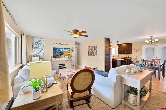 a living room with furniture a chandelier and a dining table