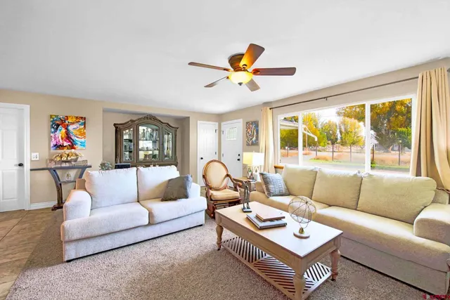 a living room with furniture a rug and a large window