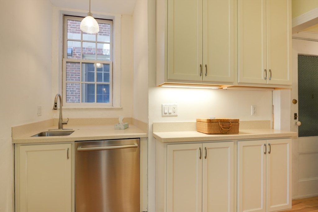 983 Memorial Drive, Unit 502 Cambridge, MA 02138 - Photo 12 of 33 a kitchen with stainless steel appliances granite countertop white cabinets and a sink