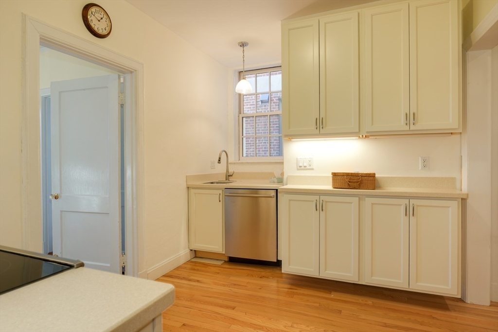 983 Memorial Drive, Unit 502 Cambridge, MA 02138 - Photo 13 of 33 a kitchen with a refrigerator stove and white cabinets