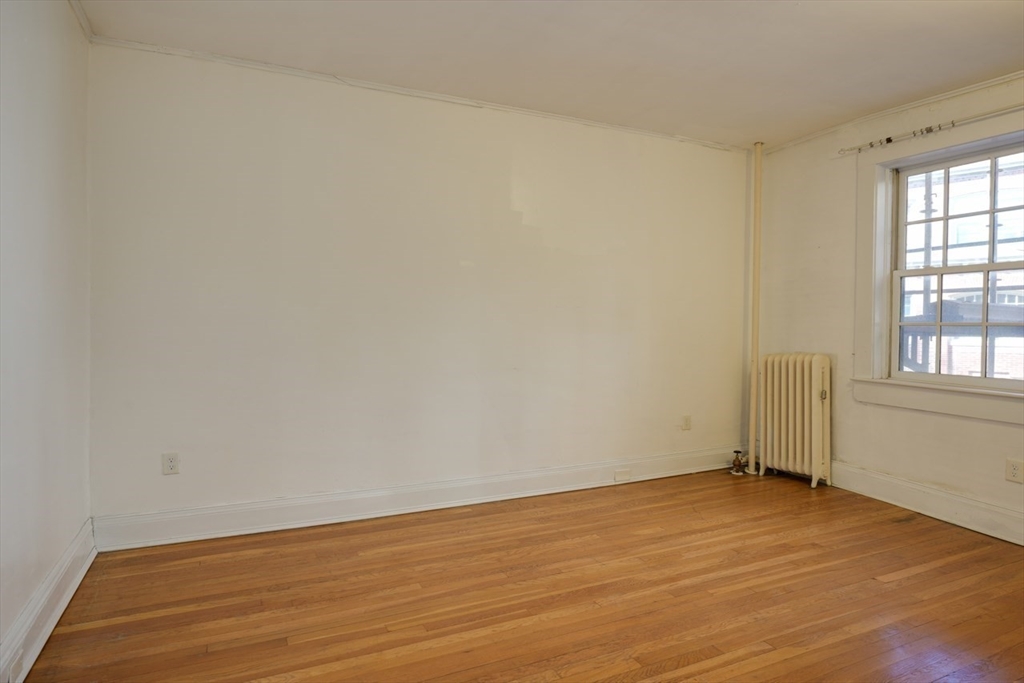 983 Memorial Drive, Unit 502 Cambridge, MA 02138 - Photo 24 of 33 an empty room with wooden floor and windows