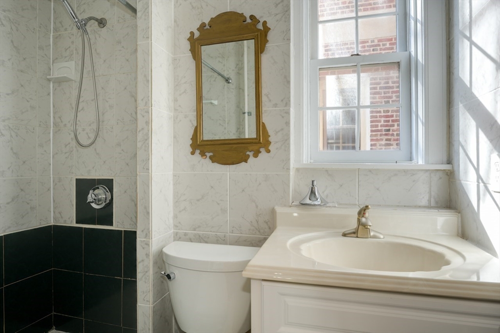 983 Memorial Drive, Unit 502 Cambridge, MA 02138 - Photo 27 of 33 a bathroom with a sink a toilet and a shower