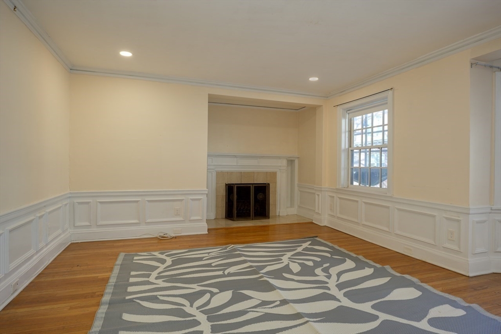 983 Memorial Drive, Unit 502 Cambridge, MA 02138 - Photo 6 of 33 a view of an empty room with a fireplace and wooden floor
