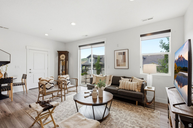 3355 Santa Fe Road Park City, UT 84098 - Photo 2 of 45 Open-concept living area featuring light wood-finish flooring, white walls, recessed lighting, and a sliding glass door to a balcony