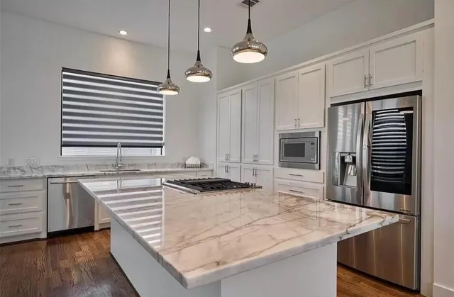 a kitchen with stainless steel appliances granite countertop a sink a stove and a refrigerator