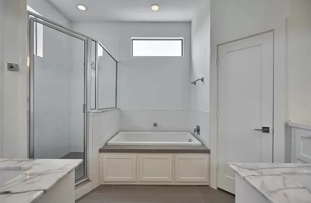 a spacious bathroom with a tub shower and sink