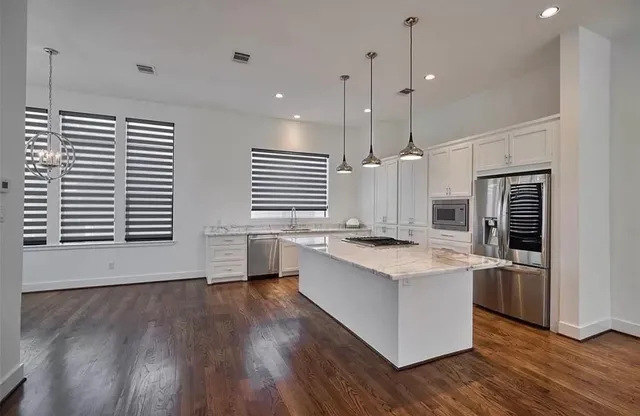 a kitchen with stainless steel appliances granite countertop a stove oven and a wooden floors