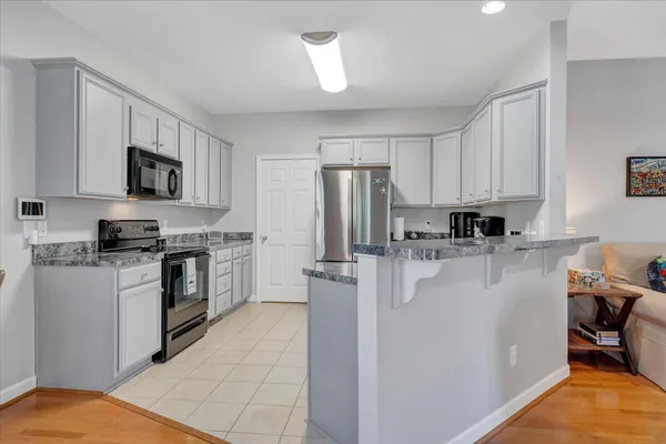 a kitchen with stainless steel appliances granite countertop a refrigerator stove and sink
